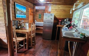 Our cozy cabin features a charming. Including a refrigerator, stove, coffe pot, preparing meals feels like a breeze. Also has water to drink, some plates, cups, glass. Of course has Air condit