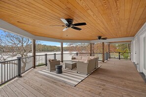 Upper level deck with sectional and ceiling fan.