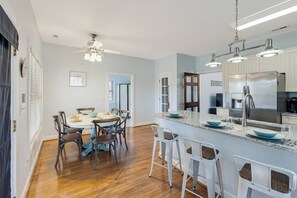 Spacious kitchen with dining table that has seating for 6, plus a breakfast bar with seating for 4.