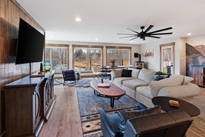 Relax in the spacious, light-filled living area with cozy seating, stunning river views, and a rustic-modern design. Perfect for unwinding after a day of adventure near Glacier National Park in Kalispell, MT.
