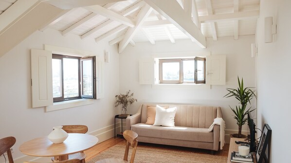 Unwind in this airy living room featuring exposed beams, a cozy sofa, and natural light streaming through charming windows. Perfect for relaxing after exploring Porto.
#PortoApartment #AiryInteriors #NaturalLight