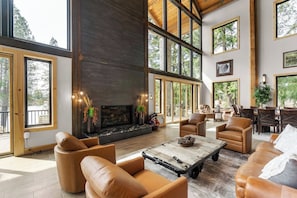 Moving further, you'll find the cozy fireplace area. A gas fireplace takes center stage, flanked by a comfortable sofa, a pair of overstuffed chairs, and a stylish coffee table, creating a warm and inviting atmosphere.