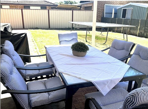 Spacious backyard with outdoor dining, refrigerator and enclosed yard for pets