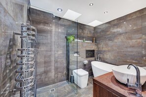 Bathroom with a walk in shower and bath. Complimentary toiletries are provided.
