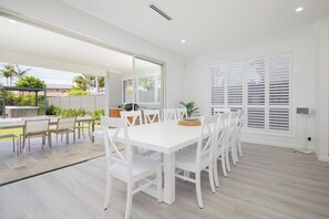 Enjoy the spacious open-plan dining area, perfect for hosting large groups, with easy access to the outdoor patio through sliding glass doors.
