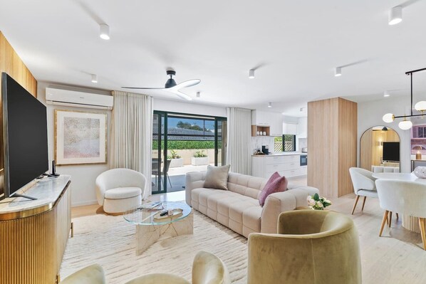 This open plan living and dining space is beautifully styled with modern amenities and accents.