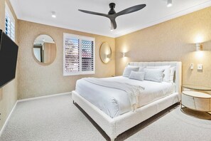 Relax in the serene primary bedroom, featuring a plush queen bed and a modern ensuite hidden behind a stylish wardrobe door.