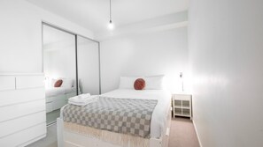 Rest easy in this comfy queen-size bed with fresh linen, ensuring a peaceful night's sleep.