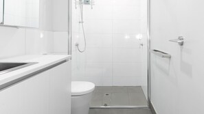 A simple and functional bathroom with a shower and toilet for your convenience.