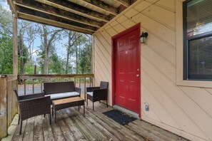 Charming red door welcomes you to a peaceful outdoor seating area.