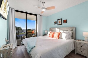 Cozy master bedroom with private ensuite bath. King bed, access to balcony, Smart TV, nightstands with storage and charging stations. 