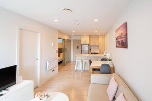 Spacious living room, dining table, sofa, TV.