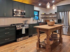 The full sized kitchen with stove, dishwasher, microwave and fridge