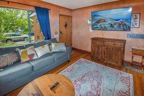 Another angle of the living room highlights its spacious layout, cozy seating, and inviting ambiance, perfect for relaxation and entertainment.