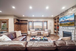 Relax and unwind in the warmth of this beautifully appointed living area, which features comfortable seating, a welcoming fireplace, and stunning views from Trumpeter Swan's terrace level.
