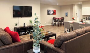 The spacious living area provides comfortable seating on Ashley fabric furniture to enjoy your favorite shows on our 65" 4K TCL ROKU Smart TV.