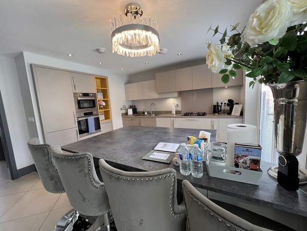 Large open plan kitchen with breakfast bar, dishwasher, insinkerator, fridge, freezer, oven, microwave and gas hob