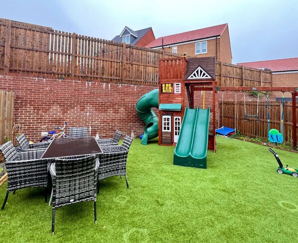 Rear enclosed garden with childrens play area and sitting