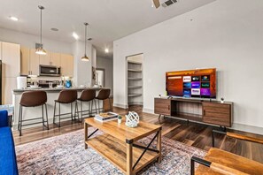 Bright and airy living room with plush seating, a large TV, and tasteful decor, creating the perfect space for relaxation and entertainment.