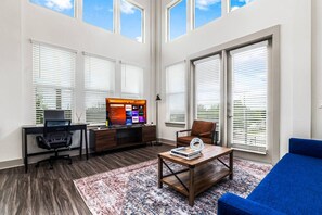 Bright and airy living room with plush seating, a large TV, and tasteful decor, creating the perfect space for relaxation and entertainment.