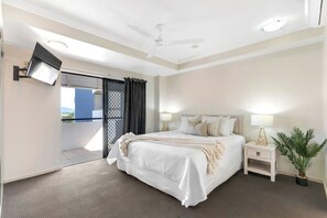 The primary bedroom opens to the balcony, and comes with its own TV, king-sized bed and ensuite bathroom.