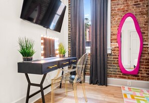 A sleek vanity area with natural light and a chic chair, ideal for getting ready for a night out or catching up on work during your stay.