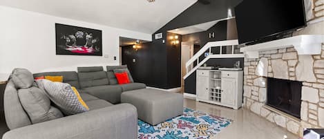 Unwind in this expansive living room featuring a plush sectional and a large TV, perfect for movie nights or relaxing after a day of adventure.