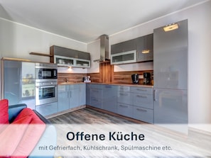 Vollständig ausgestattete Küchenzeile mit Kühlschrank, Spülmaschine, Herd, Ofen etc.