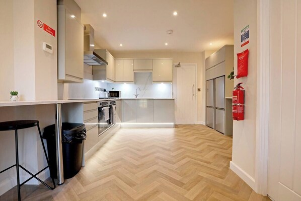 Spacious, fully equipped kitchen with a breakfast bar, modern appliances, and ample counter space, serving as the perfect communal area for dining and socializing.