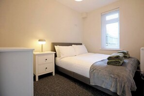 Cozy bedroom featuring a plush double bed, fresh linens, and ample storage, offering a peaceful retreat for a comfortable stay.