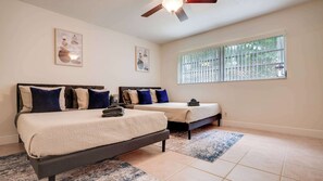 Spacious bedroom with two cozy double beds, perfect for a relaxing stay.