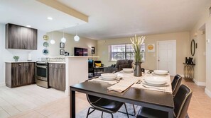 Modern open-plan kitchen and dining area with stylish decor and cozy living space, perfect for relaxing and entertaining.