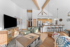 Living area featuring a large smart TV, gas fireplace, and balcony access.