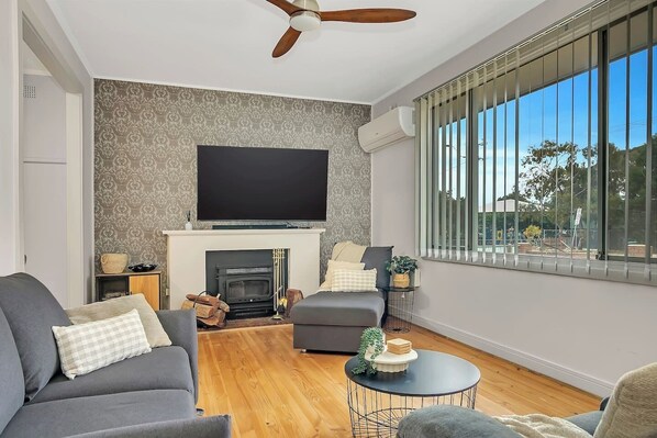 Get comfortable in the living area. There’s ample sofa seating fronting a fireplace and TV.
