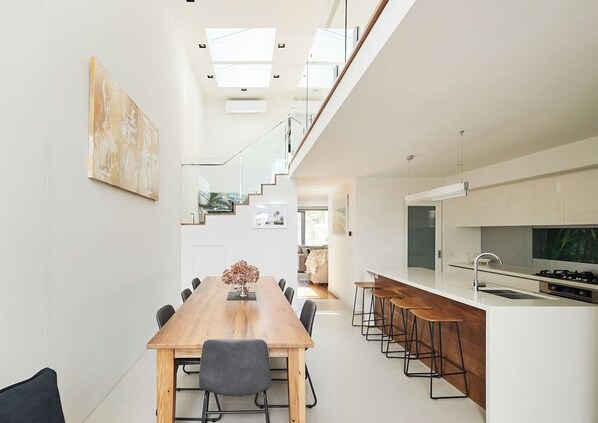 The open-plan kitchen and dining area, with its soaring high ceilings, creates a spacious and inviting setting perfect for entertaining.