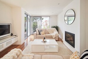 The living area is bright and cosy, with a gas fireplace adding warmth and ambience.