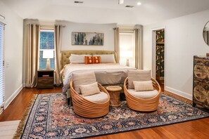 Stretch out and relax in the spacious primary bedroom, featuring a king bed, cozy reading chairs, and soft lighting