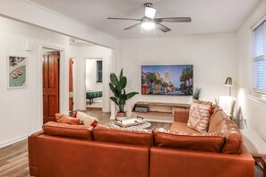 Relax and unwind in our cozy living room featuring a spacious leather sectional, smart TV, and warm, inviting vibes