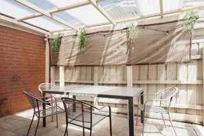 Enjoy alfresco dining rain or shine in this covered outdoor patio area.
