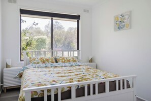 The tranquil primary bedroom comes complete with comfortable queen bedding and plenty of natural light to greet you in the morning.
