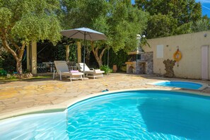 Sunloungers next to swimming pool