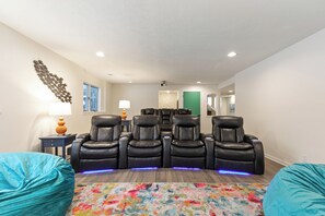 Ultimate theater room with bean bags, wet bar, stadium seating, and a massive 165" projector screen!