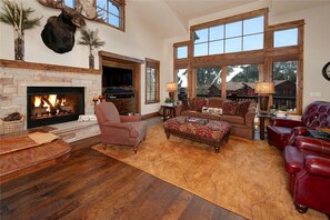 Living area featuring a gas fireplace, TV, ample seating and access to the private deck.