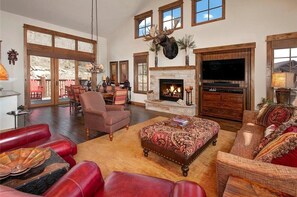 Living area featuring a gas fireplace, TV, ample seating and access to the private deck.