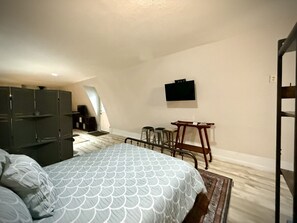 Queen bed with privacy screen between sleeping area and the futon.