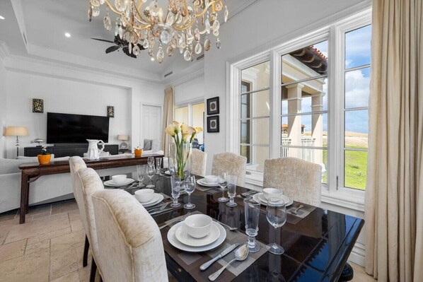 Elevate your dining experience under the glow of a stunning chandelier, creating the perfect ambiance for every meal.