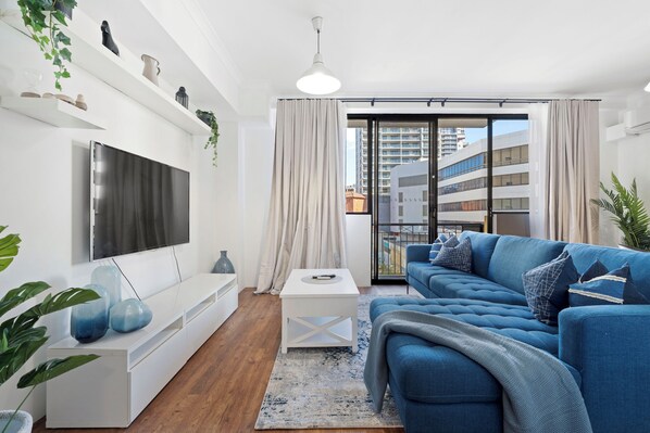 Relax in a cozy living room furnished with a comfortable couch, a stylish coffee table, and a TV, perfect for unwinding after a long day.