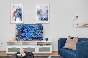 Brighten your living space with a pop of color, featuring a stylish blue sofa and coordinated artwork, creating a vibrant and inviting atmosphere.