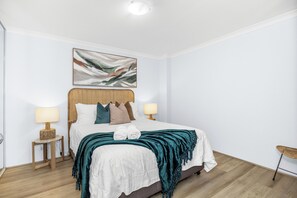 Add a touch of texture and warmth to your bedroom with a cozy, teal throw blanket, creating a comfortable and stylish focal point.