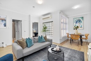 Enjoy a spacious living room furnished with two couches, a stylish coffee table, and a view of the kitchen, creating an open and inviting atmosphere.